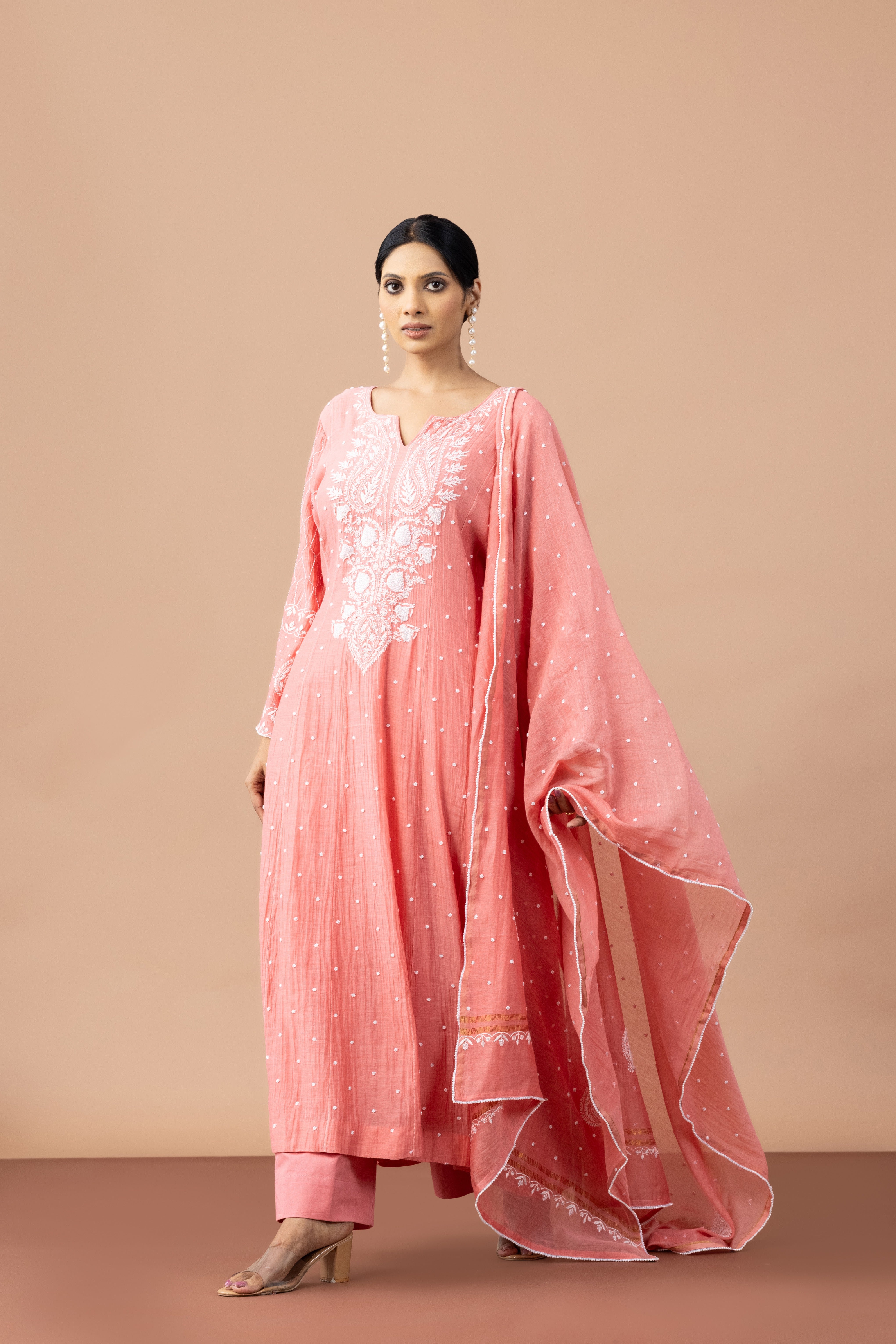 Woman wearing a pink traditional outfit with a beige background